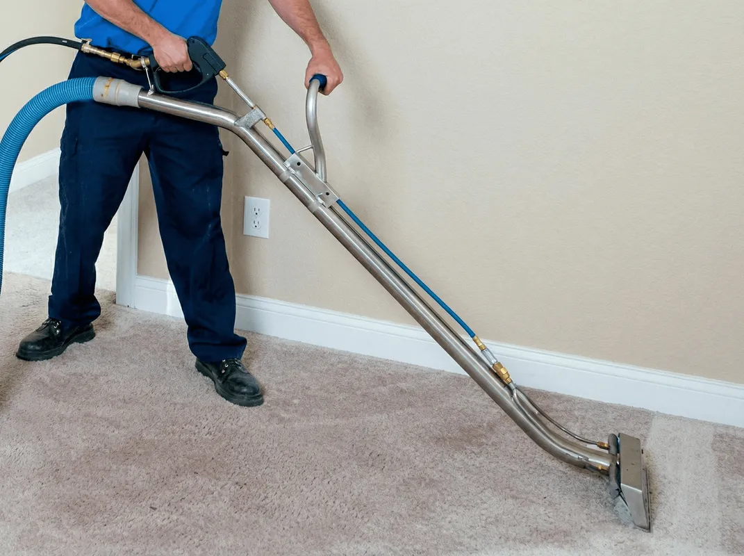 Professional operating a liquid removal machine on a carpeted floor in Pittsburgh, PA